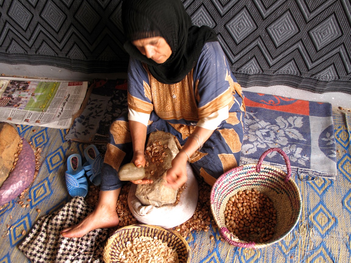 Mujer pelando semillas de argán